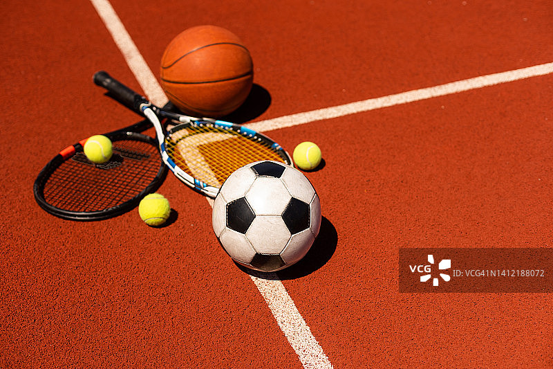黑色背景上的一组运动器材，包括网球、篮球、足球和拳击器材，背景上有拷贝空间图片素材