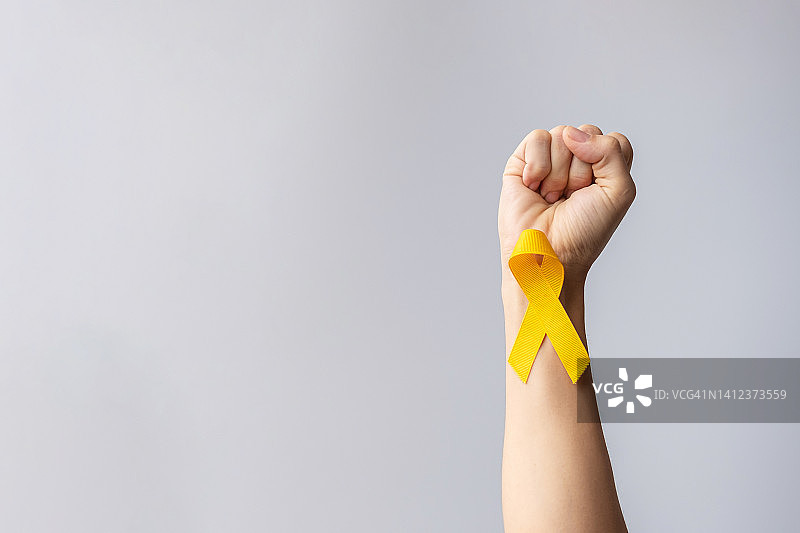 预防自杀日，儿童，肉瘤，骨和膀胱癌宣传月，支持人们生命和疾病的黄丝带。儿童保健和世界癌症日的概念图片素材