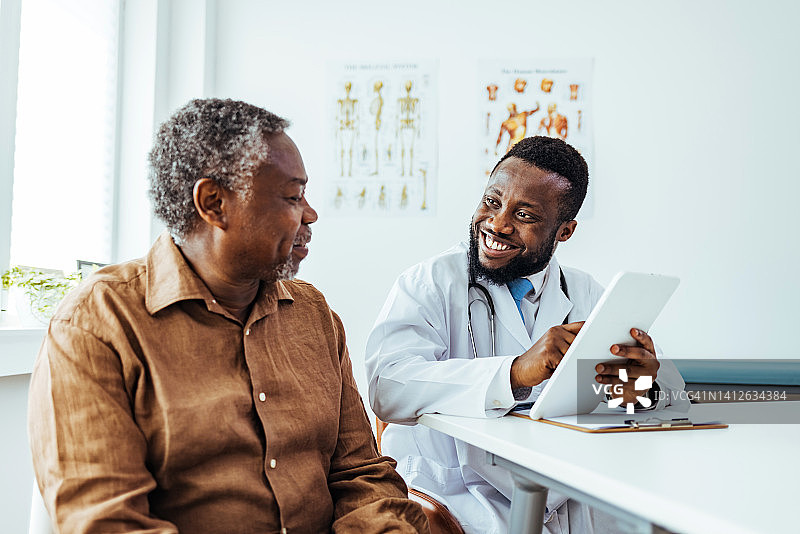 年轻的医生通过他的电子平板电脑与一位年长的病人分享信息图片素材
