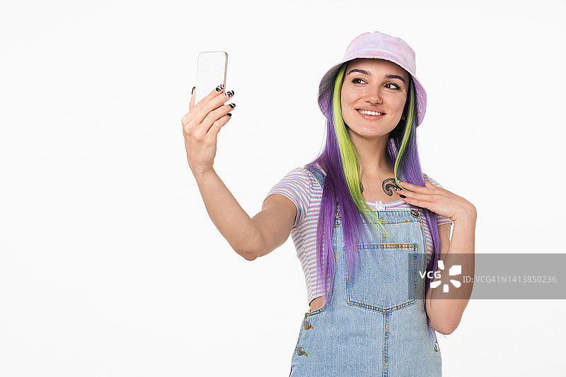 视频博客博客的概念。白人年轻少女潮女孩使用手机自拍照片发布在社交媒体在线孤立的白色背景图片素材