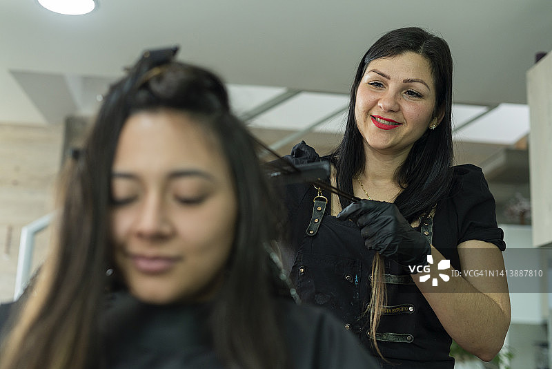 一位美发沙龙的女老板为她的客户染发图片素材