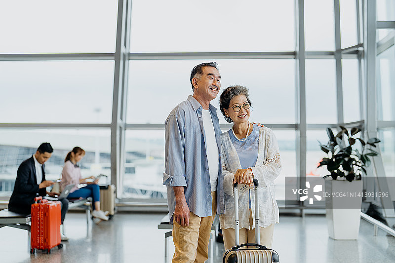 微笑的亚洲老年夫妇游客在机场图片素材