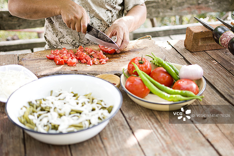 在木板上切蔬菜或准备沙拉的人图片素材