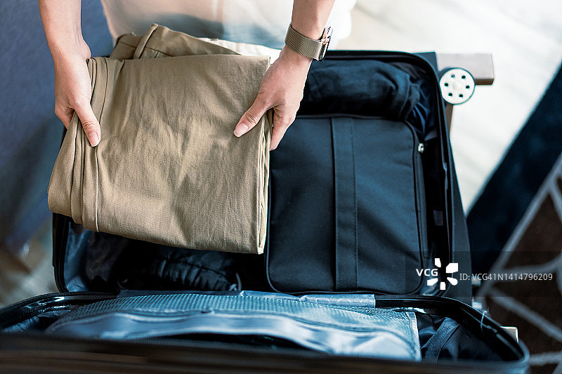 一个女人在整理旅行用的行李箱图片素材