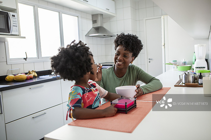 母亲和女儿在厨房吃健康的食物图片素材