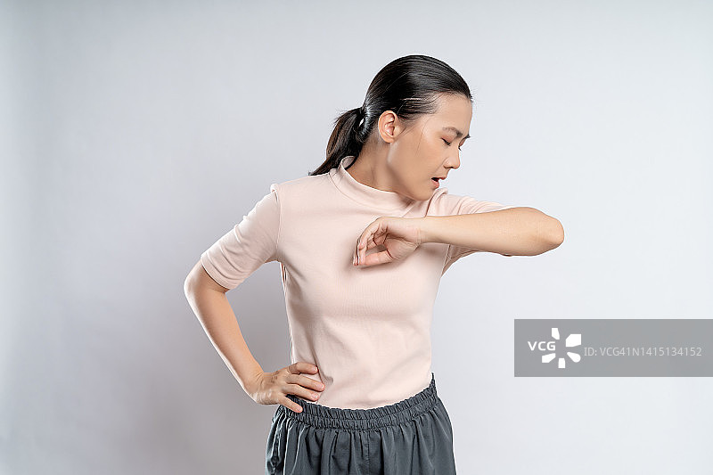 一名亚洲妇女喉咙痛，孤立地站在白色背景上。图片素材