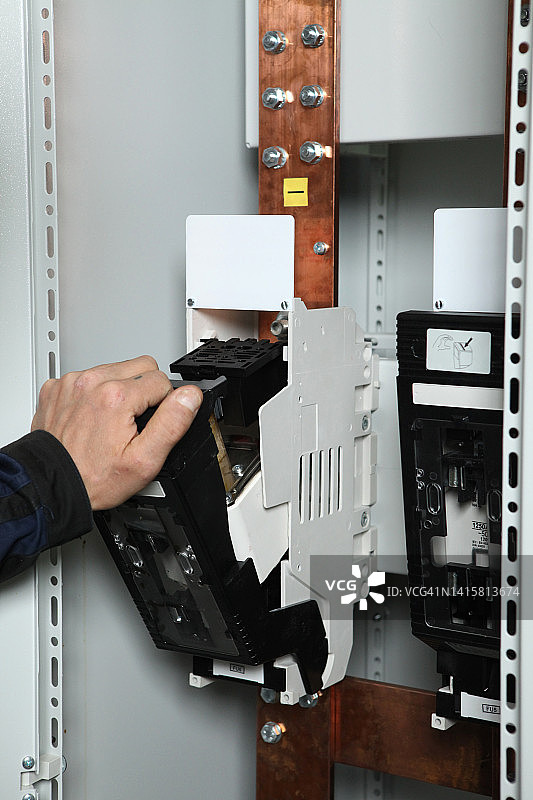 电工工程师工作测试仪测量电控箱控制中电力线路的电压和电流。以及继电保护系统上的电线。湾控制单元。中压开关设备。图片素材