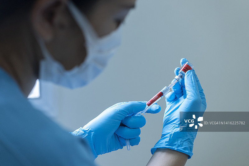 医生手注射器接种猴痘抗病毒新毒株用小瓶疫苗和血液检测管图片素材