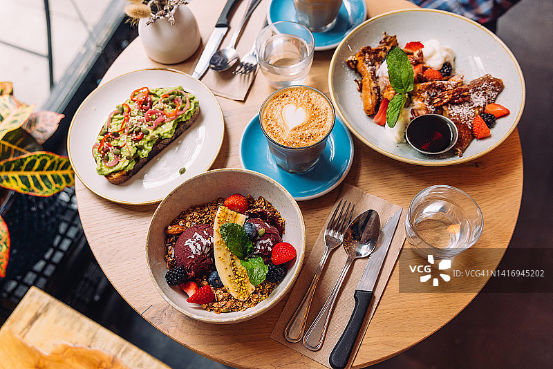 咖啡馆的健康早餐，巴西莓碗，法式吐司和牛油果吐司，特写图片素材