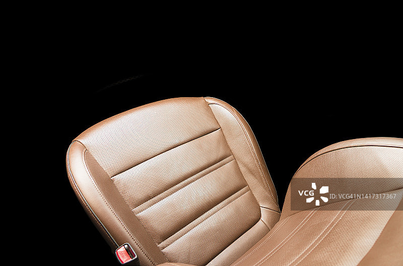 现代豪华汽车棕色皮革内饰。部分橙色皮革汽车座椅细节与白色缝合。高级轿车的内饰。舒适的穿孔真皮座椅。穿孔皮革。图片素材