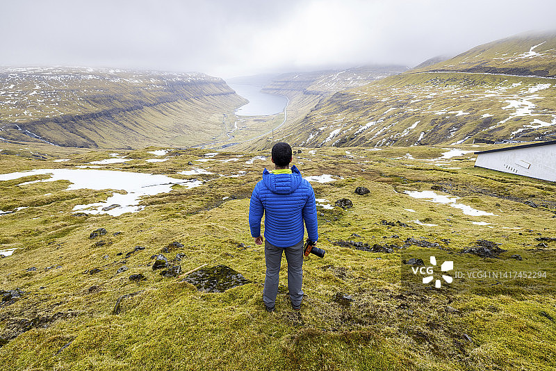 一名男性徒步旅行者俯瞰Kaldbaksfjordur峡湾图片素材