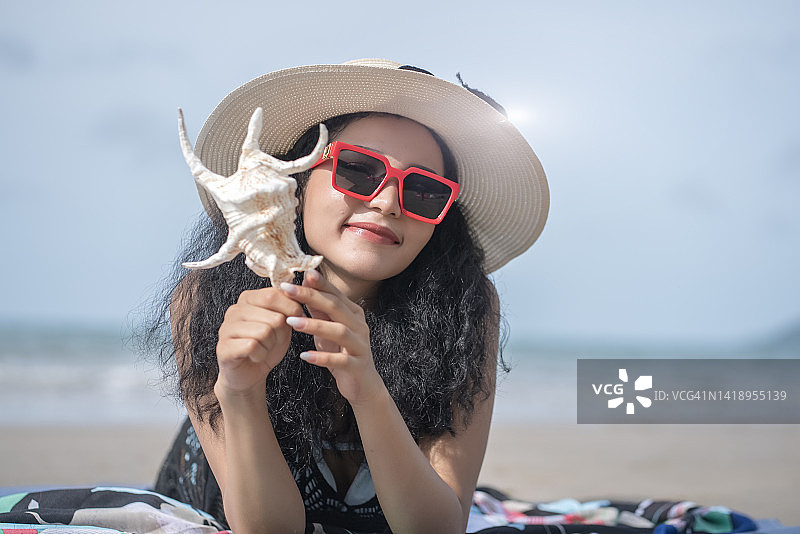 在沙滩上穿着比基尼的快乐年轻亚洲女人的肖像，快乐的假期，旅行，亚洲。泰国。图片素材