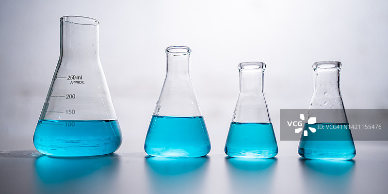 化学科学实验室，试管烧杯和玻璃器皿设备中有蓝色液体，生物或化学和医学生物技术实验，科学玻璃图片素材