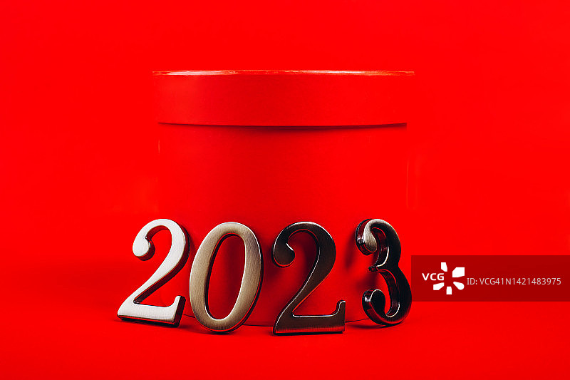 2023年，靠在红色背景的礼品盒上。图片素材