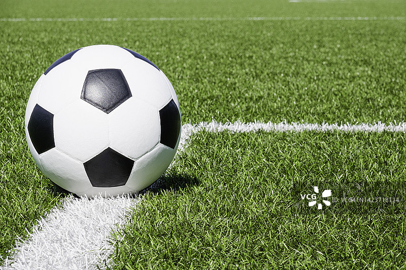 足球在绿色合成人造草地足球运动场上有白色的边角条纹线图片素材