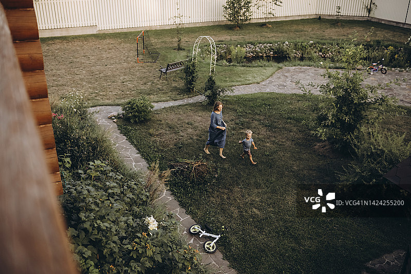 母亲和儿子在花园散步的高角度视图图片素材