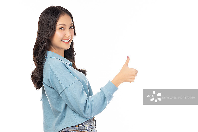 微笑美丽的年轻女子显示拇指孤立在白色背景工作室年轻快乐有趣的亚洲女孩看着相机显示拇指手势与微笑的脸美丽的女士感觉幸福图片素材