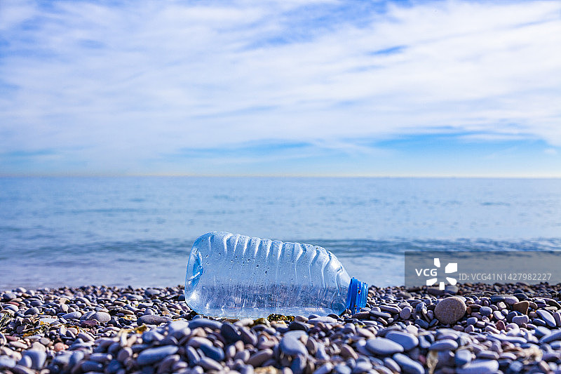 丢弃在海滩上的塑料瓶。塑料污染环境的概念。垃圾造成的生态问题。图片素材