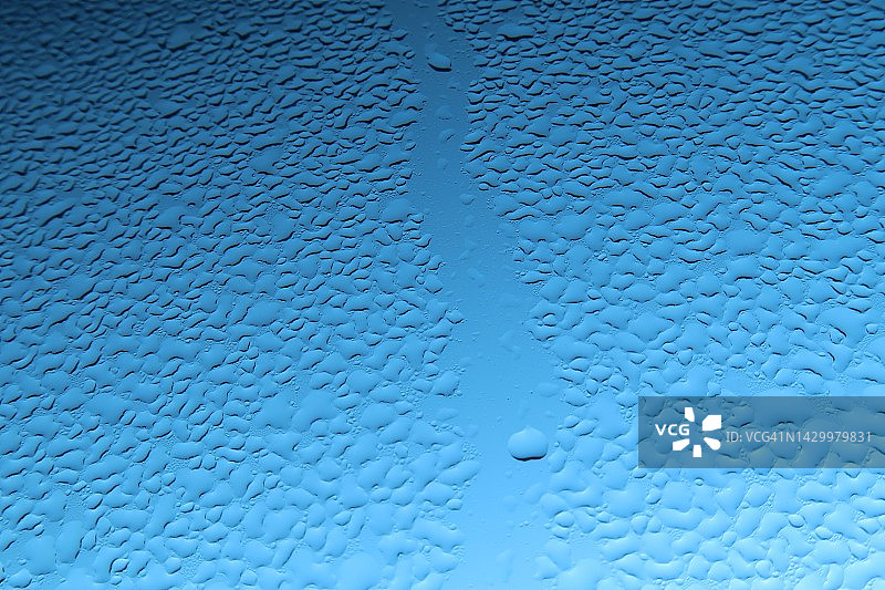 水滴在玻璃上，蓝色的天空背景图片素材