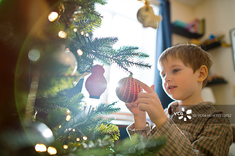 可爱的小男孩在装饰圣诞树图片素材