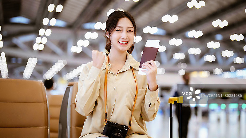 亚洲妇女在机场等待离开假期假期。肖像微笑的亚洲年轻女子看着相机。面部表情快乐图片素材