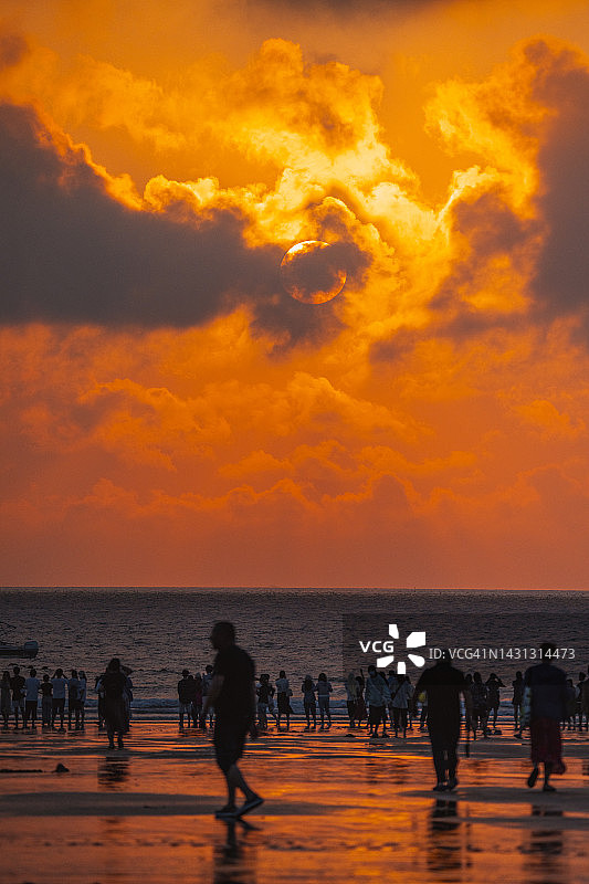 旅行者在海滩上看早晨的超级日出图片素材