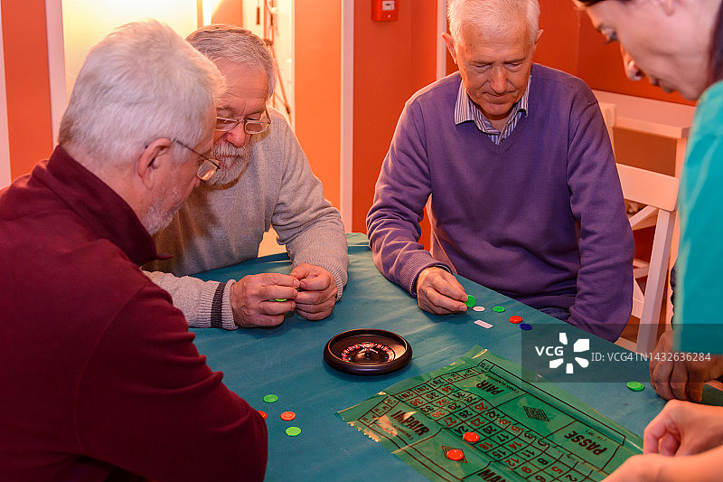 一群退休人员正在家中玩轮盘赌。图片素材