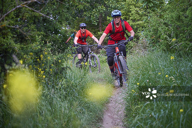 山地自行车骑手骑着狭窄的小路穿过森林图片素材