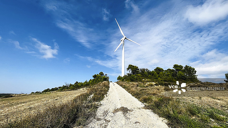 在西班牙莱里达的农田里，以天空为背景的风力涡轮机图片素材