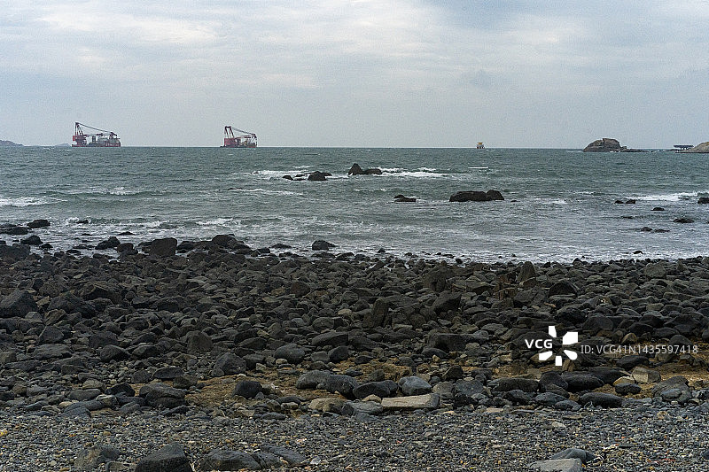 海边海滩上的黑色石头图片素材