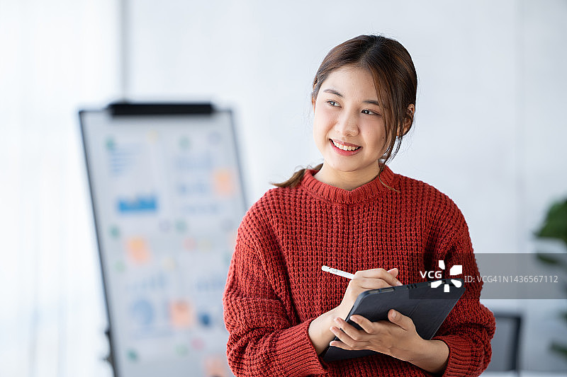 亚洲女人笑着开心地用平板电脑开会上班图片素材