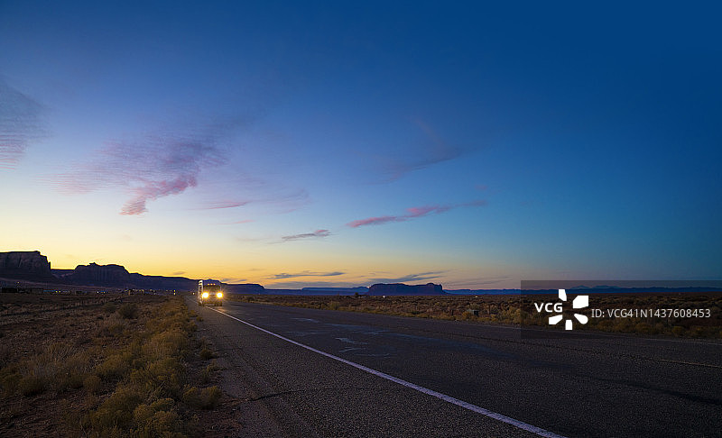 货车行驶在美国亚利桑那州纪念碑谷的乡村道路上图片素材