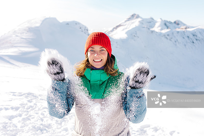 女人在山上玩雪玩得很开心。图片素材