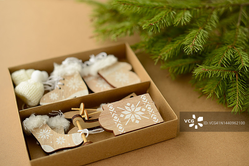 圣诞或新年背景与圣诞树树枝，纸板箱装饰木制玩具-滑雪板，雪橇，溜冰鞋，手套，帽子，俯视图图片素材