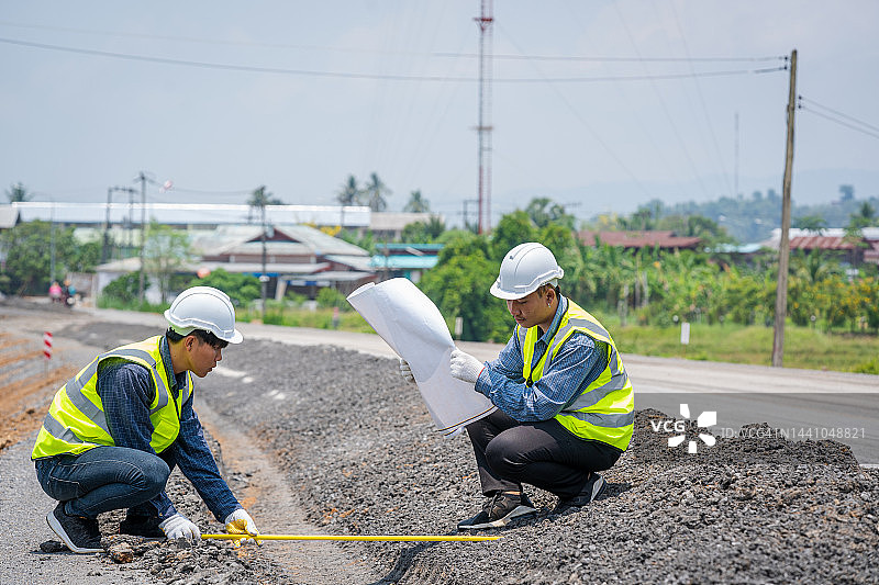 道路工程期间，工程人员在建筑工地进行测量。图片素材