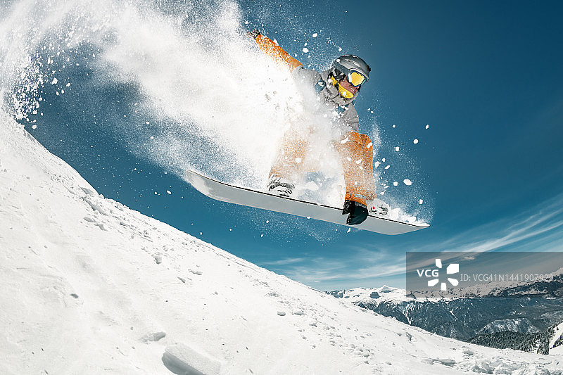 专业滑雪板运动员在滑雪场跳跃图片素材
