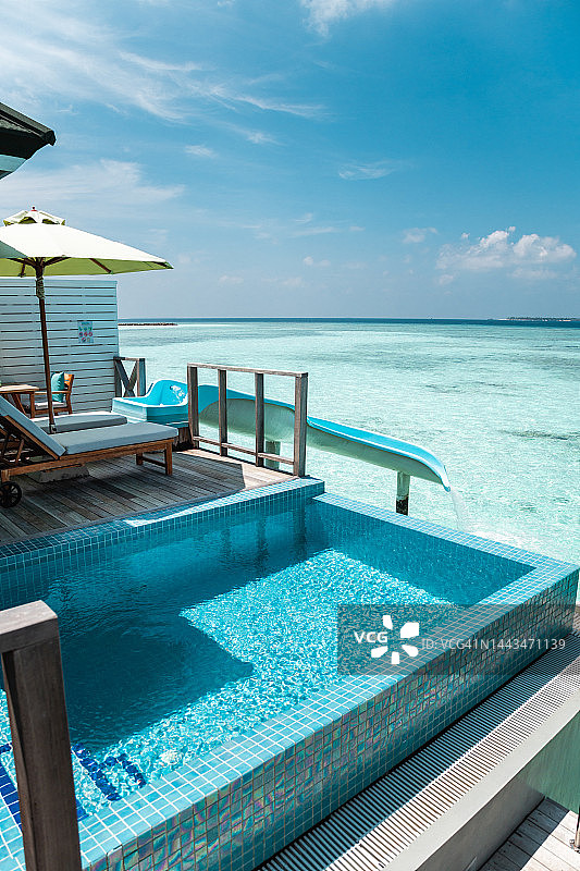 马尔代夫水别墅平房与游泳池和水滑梯到达绿松石泻湖游泳图片素材