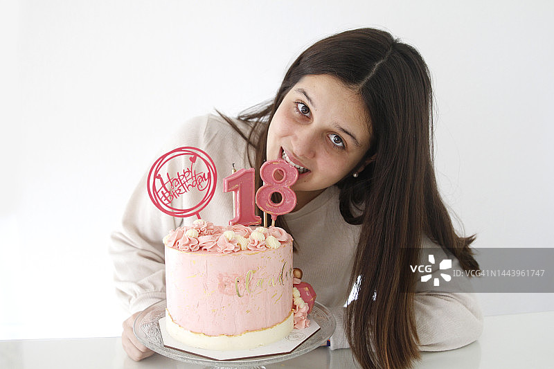 十几岁的女孩吃巧克力蜡烛从18岁生日蛋糕图片素材