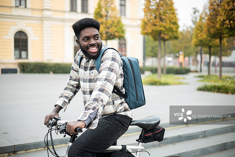 一个非裔美国人骑着电动自行车去上班的画像图片素材