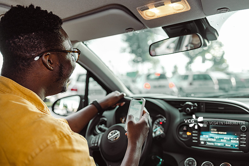 非裔美国人开车时使用智能手机图片素材