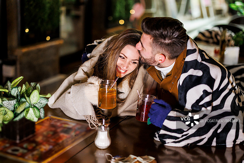 浪漫的年轻情侣在城市咖啡馆享受热茶。图片素材