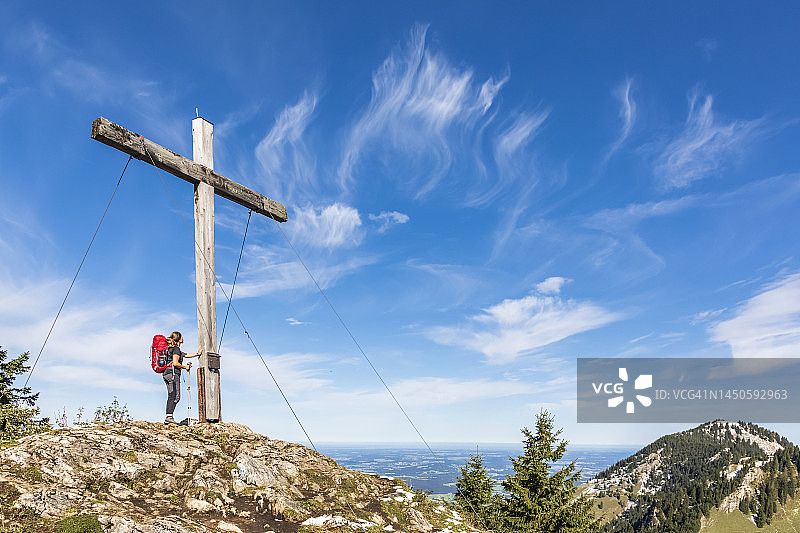 德国，巴伐利亚，女徒步旅行者站在卡尔科普夫山的山顶前图片素材