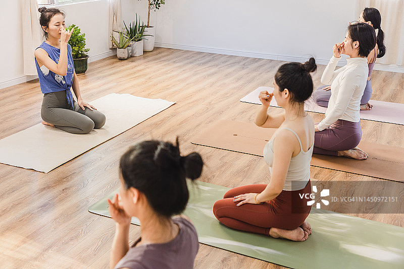 一群亚洲女性在瑜伽课上做呼吸练习图片素材
