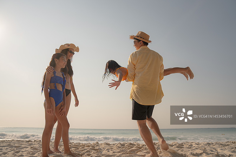 亚洲家庭假期和休闲概念。假日，快乐的亚洲家庭在海滩上一起享受。图片素材