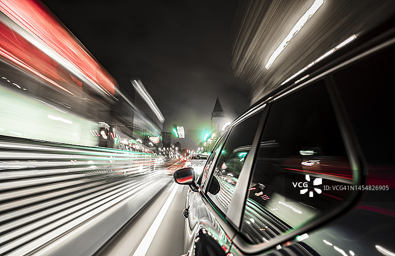 黑色电动汽车在夜晚的旧金山快速行驶。图片素材