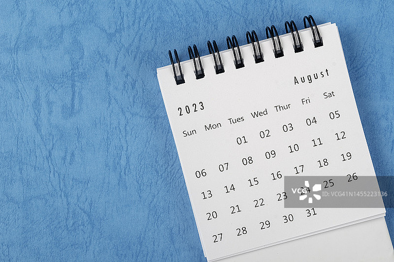 2023年日历桌面俯视图:8月是组织者用蓝色纸张背景进行计划和截止日期的月份。图片素材