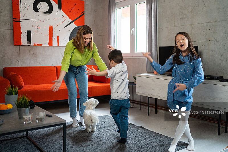 幸福的家庭在家里的客厅跳舞图片素材