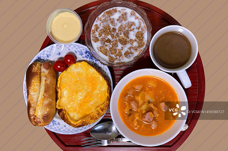 待在家里食物放在托盘上，平铺，切掉。高角度。蛋卷，面包，汤，麦片，布丁和咖啡图片素材