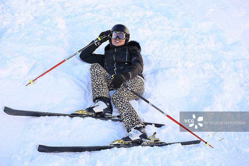 女子滑雪者躺在粉雪，滑雪道外，阿尔卑斯山脉欧洲图片素材