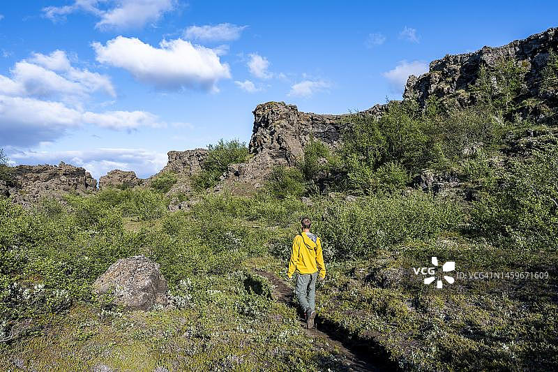 徒步旅行者之间的火山岩，克拉弗拉火山景观，Dimmuborgir熔岩田，Myvatn，冰岛图片素材